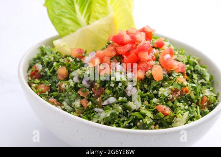 Traditioneller arabischer Salat tabbouleh, isoliert auf Marmorkulisse Stockfoto