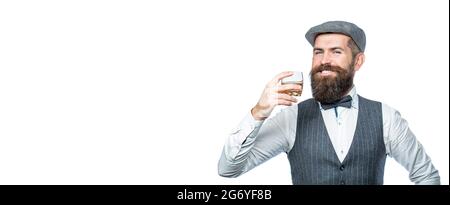 Stilvoller reicher Mann mit einem Glas alten Whisky. Bärtiger Herr trinkt Cognac. Schlürfen Sie feinsten Whiskey. Porträt des Mannes mit dicken Bart. Macho Stockfoto