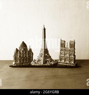 Teil eines alten Pariser Souvenir aus Plastik mit Sacre Coeur, Eiffelturm und Kathedrale Notre Dame, fotografiert in Sepia-Tönen. Stockfoto