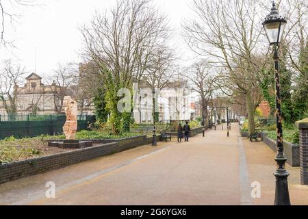 Die Clothier-Skulptur von John Atkin, viele Bäume und Hecken. Neues Walk Museum in der Ferne. In Der Nähe Des Waterloo Way. 2 Menschen halten sich die Hände beim Gehen. Stockfoto