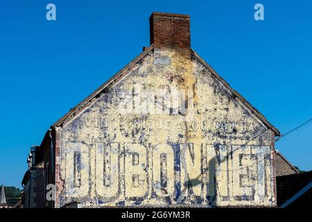 Alte Fassade mit einer bemalten Werbung im Dorf Herisson Stockfoto