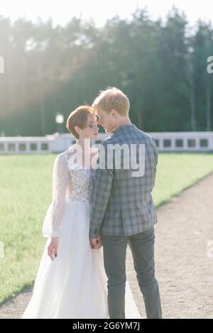 Junge Braut und Bräutigam Paar zart halten einander. Sommerhochzeit, Rotschopf weiblich und männlich. Stockfoto