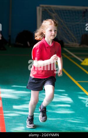 Grundschule Mädchen Kind / Kind nimmt am Schulsport Tag an einem Sommernachmittag am Ende des akademischen Jahres und Schulzeit am Rennsport Teil. Stockfoto