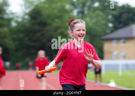 Grundjahr 4 Schulmädchen Kind / Kind nimmt an Staffellauf Rennen / Sport am Schulsporttag / Sommer / Studienjahr / Schulen Semester Ende Stockfoto