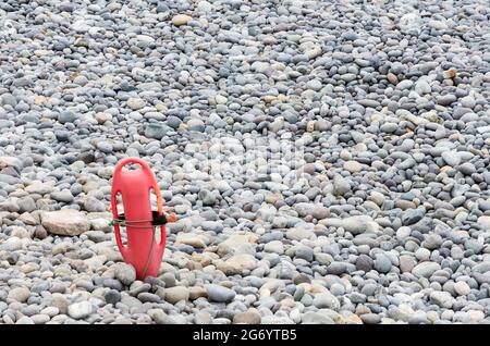 Roter Kunststoff Auftrieb im Sand am einsamen Strand. Stockfoto