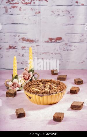 Köstliche Lucuma-Mousse mit Schokoladenbrownies auf einem Tisch mit zwei Kerzenleuchtern Stockfoto