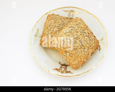 Sonnenblumenbrötchen auf Porzellan verzierten Teller auf weißem Hintergrund, Foto Stockfoto