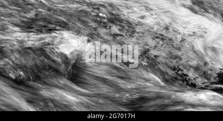 Unruhigen Wasser mit Kopf aus Schaum und Spray in schwarz und weiß als Panorama. Stockfoto