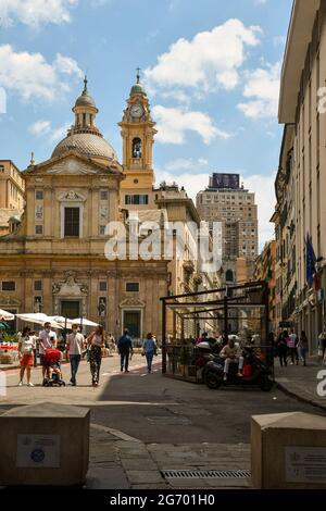 Menschen auf dem Giacomo Matteotti Platz mit der Kirche Jesu und dem Wolkenkratzer des Piacentini Turms im Hintergrund im Sommer, Genua, Ligurien, Italien Stockfoto