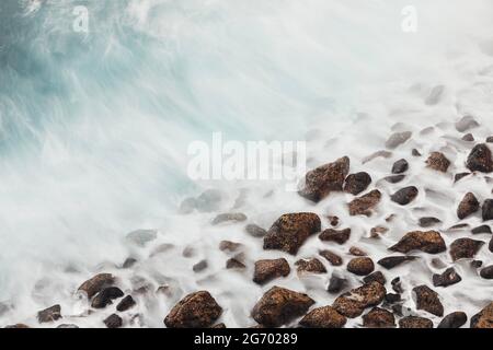 Blick auf den Steinstrand. Meereswellen in Bewegung. Teneriffa, Kanarische Inseln, Spanien. Stockfoto