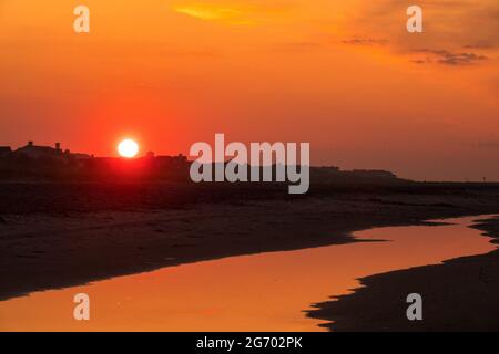 Die Sonne geht über Häusern und Sanddünen am Strand auf der Isle of Palms, South Carolina, auf. Stockfoto