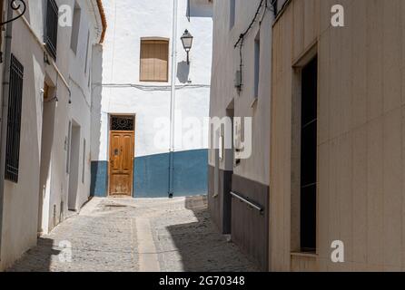 Schmale Gasse zwischen weißen Gebäuden voller Sonnenschein Stockfoto