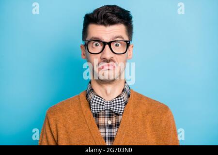 Foto von schockiert funky junge Mann tragen Brille kariert Hemd Fliege isoliert auf blauem Hintergrund Stockfoto