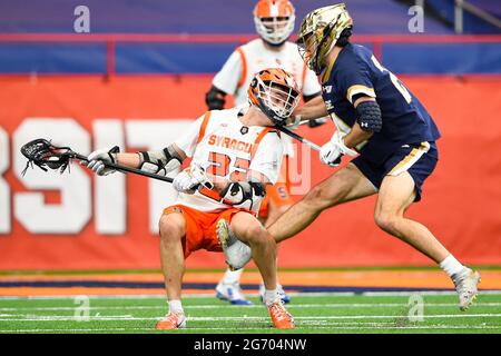 Syracuse, New York, USA. April 2021. Der Angreifer Chase Scanlan (22) von Syracuse Orange weicht dem Tor aus, als Notre Dame gegen den irischen Mittelfeldspieler Ryan Hallenbeck (24) in der zweiten Hälfte eines NCAA-Herren-Lacrosse-Spiels am Samstag, dem 3. April 2021, im Carrier Dome in Syracuse, New York, verteidigt. Notre Dame gewann 18-11. Rich Barnes/CSM/Alamy Live News Stockfoto