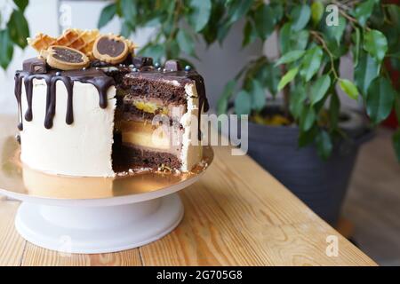 Schokoladenkuchen mit Schokoladenkeksen auf Holztisch in der Küche Stockfoto