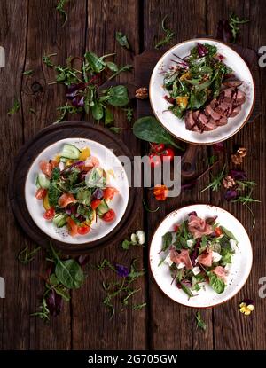 Auswahl an frischen Gemüsesalaten flach gelegt. Blick von oben auf das vegetarische Buffet mit leckeren Beilagen. Gesunde Ernährung Stockfoto