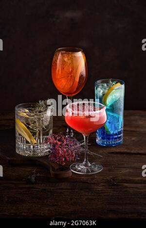 Verschiedene schöne Cocktails in warmen Farben auf dunklem Hintergrund. Stockfoto