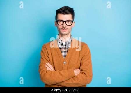 Foto von ernst gut aussehenden jungen Mann gekreuzte Hände tragen Brille Fliege auf blauem Hintergrund isoliert Stockfoto