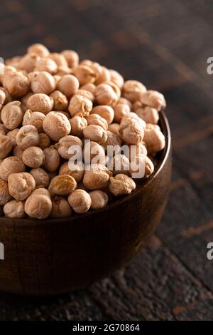 Eine Schüssel mit trockenen Kichererbsen auf einem rustikalen Holztisch Stockfoto