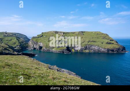 Die neue Tintagel Castle Fußgängerbrücke zur Tintagel Castle Island mit Ruinen, Merlins Cave und Tintagel Haven Cove. Vom South West Coast Path. Stockfoto