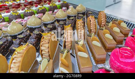 In einer französischen Patisserie werden bunte Gebäckstücke mit Früchten serviert Stockfoto