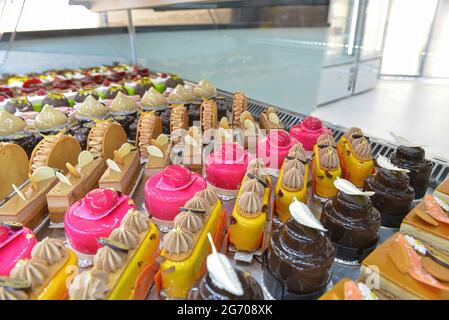 In einer französischen Patisserie werden bunte Gebäckstücke mit Früchten serviert Stockfoto