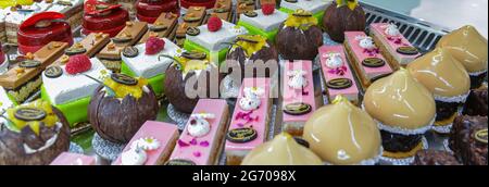 In einer französischen Patisserie werden bunte Gebäckstücke mit Früchten serviert Stockfoto