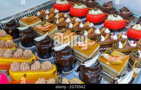 In einer französischen Patisserie werden bunte Gebäckstücke mit Früchten serviert Stockfoto