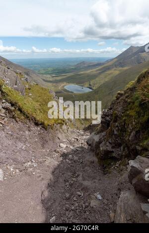 Vertikale Aufnahme von hohen Bergen und einem kleinen See im Killarney National Park, Irland Stockfoto