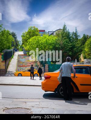 Ankara, Türkei-Mai 23 2021: Kundin steigt mit einer weiteren Taxifahrt und einem Paar im Hintergrund in ein Taxi ein Stockfoto