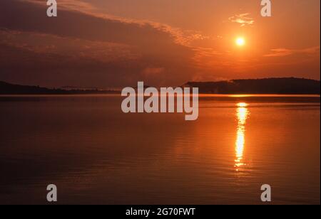 Ein roter Sonnenaufgang mit etwas Nebel über dem Kawawaymog Lake, Algonquin, Ontario, Kanada. Stockfoto