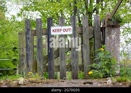 Das hölzerne Landtor und der Zaun mit dem Schild Eintritt verboten. Stockfoto