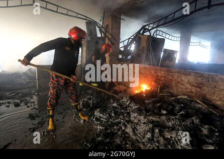 Narayanganj, Bangladesch. Juli 2021. (210709) -- NARAYANGANJ (BANGLADESCH), 9. Juli 2021 (Xinhua) -- Feuerwehrleute arbeiten am 9. Juli 2021 auf der Feuerstelle einer Saftfabrik in Narayanganj am Stadtrand von Dhaka, Bangladesch. Mindestens 52 Menschen sind gestorben, als ein riesiges Feuer einen zweiten Tag lang in der Saftfabrik in Narayanganj wütete. (Xinhua) Quelle: Xinhua/Alamy Live News Stockfoto