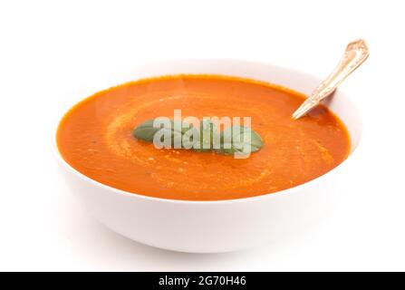 Schüssel mit hausgemachter Tomatencreme und Basilikumsuppe Stockfoto