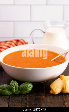 Schüssel mit hausgemachter Tomatencreme und Basilikumsuppe Stockfoto
