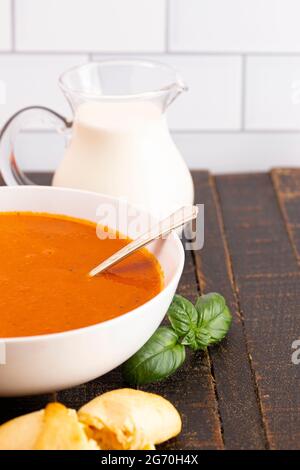 Schüssel mit hausgemachter Tomatencreme und Basilikumsuppe Stockfoto
