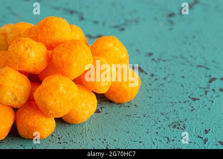 Mit Käse überzogene Kugelsnacks auf einem Teal-Tisch Stockfoto