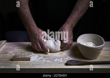 Nahaufnahme von Menschenhänden, die Sauerteig-Brot kneten Stockfoto