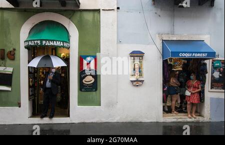 Geschäfte in der Calle De La Fortaleza und Porträt von Jesus Christus bei einem starken Nachmittagsregen im alten San Juan, Puerto Rico, USA. Stockfoto