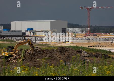 West Hyde, Großbritannien. Juli 2021. Ein Bagger bewegt die Überreste von gefällten Bäumen vor präzisionsgefertigte Tunnelsegmente am Standort South Portal für den Tunnelabschnitt Chiltern der Hochgeschwindigkeitsstrecke HS2. HS2 Ltd hat den Start der zweiten 2,000-Tonnen-Tunnelbohrmaschine (TBM) bekannt gegeben, die Cecilia nach der Astronomin und Astrophysikerin Cecilia Payne-Gaposchkin benannt wurde, um einen zweiten 10-Meilen-Tunnel unter den Chilterns auszugraben. Kredit: Mark Kerrison/Alamy Live Nachrichten Stockfoto