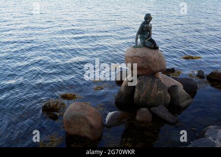 Kopenhagen, Dänemark - 2021. Juli: Die kleine Meerjungfrau-Statue (Den lille Havfrue), die auf einem Felsen am Wasser an der Langelinie-Promenade dargestellt ist Stockfoto