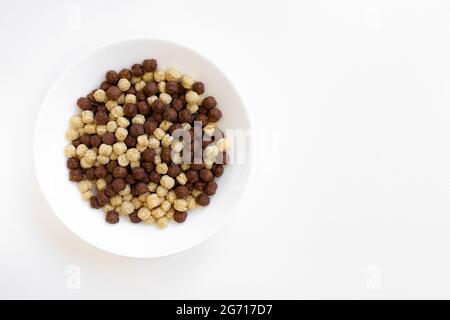 Schokolade und Vanille Müslischale isoliert auf weißem Hintergrund, Schokoladenkugeln, Konzept eines gesunden Frühstücks Stockfoto