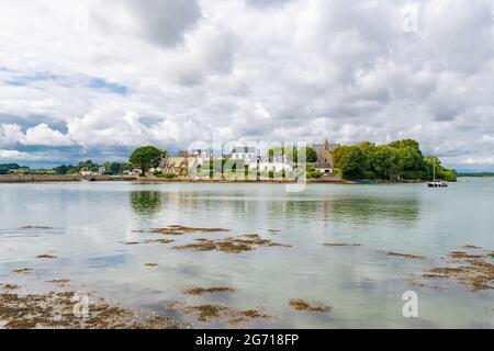Saint-Cado in der Bretagne, schöne Häuser im Dorf, auf einer kleinen Insel, mit der Kapelle im Hintergrund Stockfoto