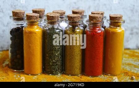 Vertikale Aufnahme verschiedener Gewürze in kleinen Glasflaschen. Stockfoto