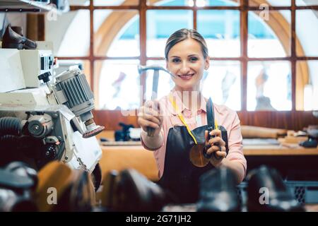 Geschäftsporträt der stolzen Besitzerin in ihrer kleinen Schusterwerkstatt Stockfoto