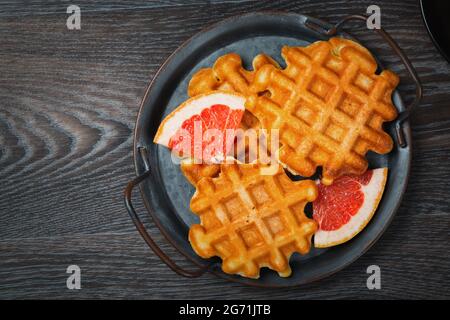 Waffelfrühstück mit Grapefruit auf einem Holztisch Stockfoto