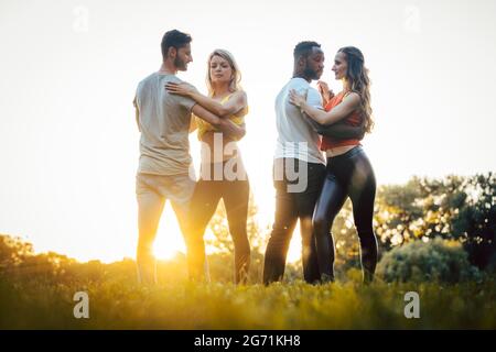 Zwei Paare tanzen fortgeschrittene Kizomba bewegt sich während Sonnenuntergang in einem Park Stockfoto