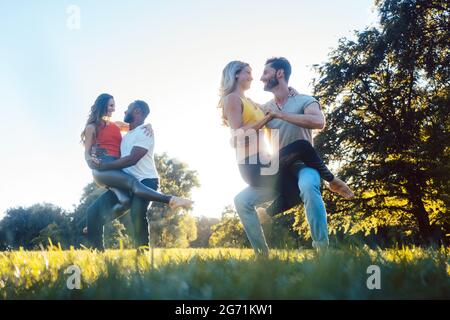 Zwei Paare tanzen fortgeschrittene Kizomba bewegt sich während Sonnenuntergang in einem Park Stockfoto