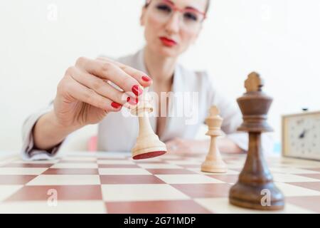 Geschäftsfrau, die strategischen Schritt im Schachspiel macht Stockfoto