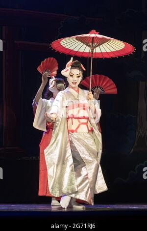 Japanische Frauen im traditionellen Kimono baumeln mit Regenschirm und Fans. Traditionelle japanische Darbietung. Stockfoto